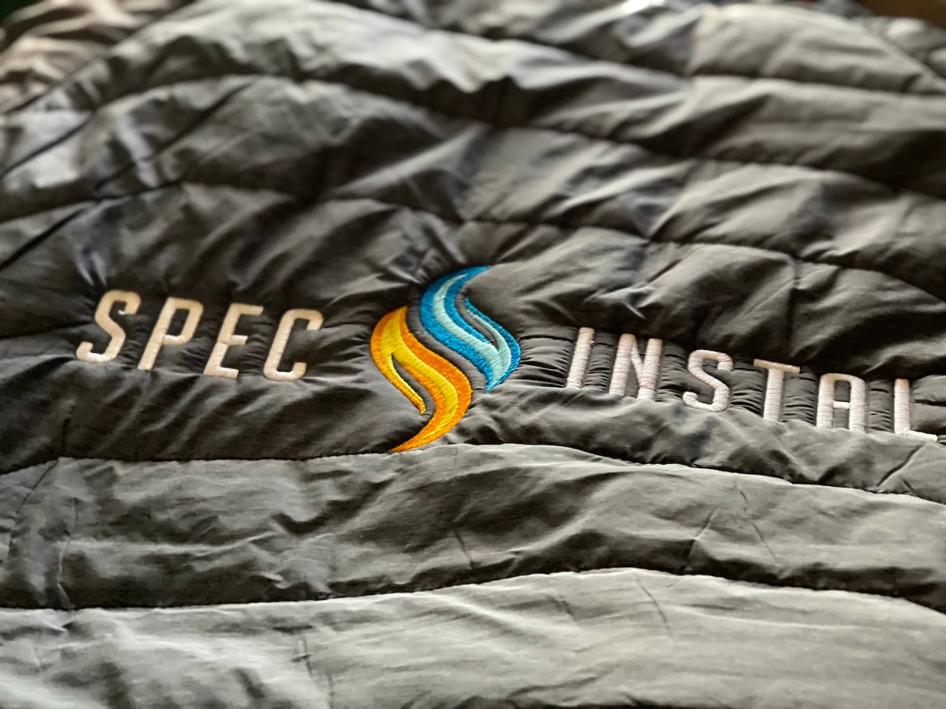 Zdjęcie przedstawia haft z logo SPEC INSTAL